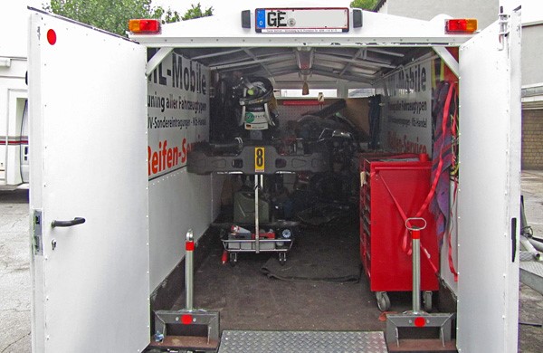 Geöffneter Anhänger mit Spezialausrüstung und rotem Werkzeugwagen